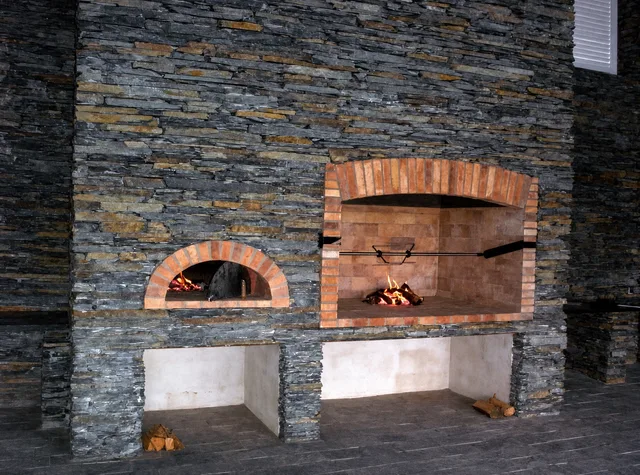 Pizza pec i&nbsp;krb pod cihlovými klenbami v&nbsp;jedné kamenné stěně, oheň hoří v&nbsp;obou